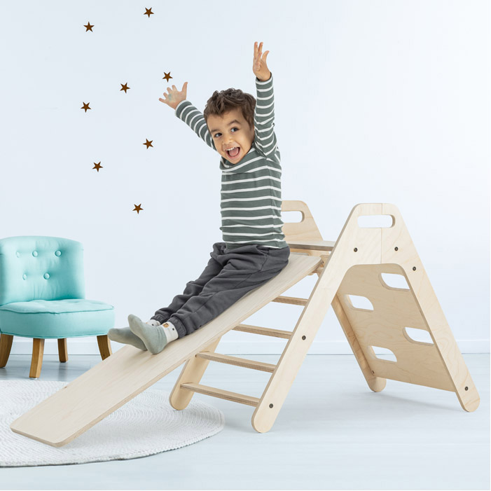 Small light blue armchair for kid standing in white room interior with stars on the wall, white rug and cupboard with books, teddy bear and fresh plant. Empty space for your crib; Shutterstock ID 1121967491; purchase_order: -; job: -; client: -; other: -